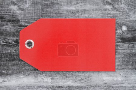 Foto de Etiqueta de regalo roja en blanco en madera negra envejecida para su mensaje de venta - Imagen libre de derechos