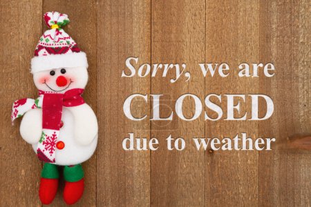 Téléchargez les photos : Désolé, nous sommes fermés en raison du temps signe avec un bonhomme de neige sur bois altéré - en image libre de droit