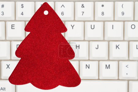 Foto de Etiqueta regalo árbol de Navidad rojo en blanco en un teclado para su mensaje de compras en línea de vacaciones - Imagen libre de derechos
