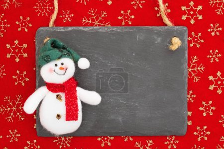 Téléchargez les photos : Panneau de tableau blanc avec un bonhomme de neige sur flocons de neige pour votre message d'hiver ou saisonnier - en image libre de droit