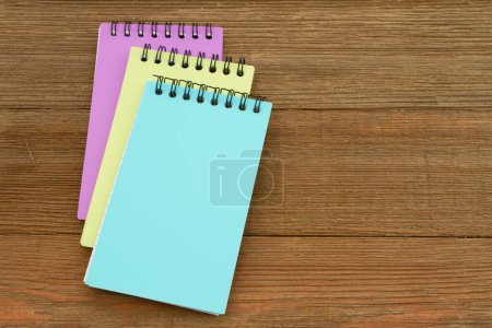 Téléchargez les photos : Three notepads on weathered wood desk for your note message - en image libre de droit