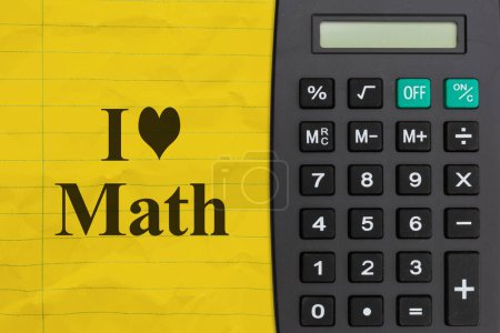 Photo for I love math message on bright yellow ruled line notebook crumpled paper with a calculator - Royalty Free Image