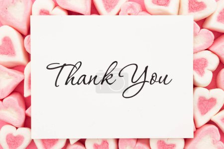 Foto de Thank you message on a white greeting card with pink and white candy hearts for your valentine or anniversary message - Imagen libre de derechos