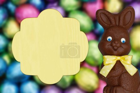 Foto de Blank sign with shiny Easter eggs greeting card with chocolate Easter Bunny for your holiday message - Imagen libre de derechos