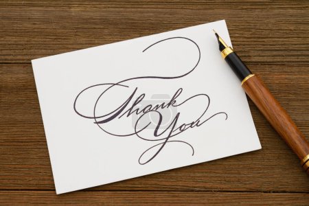 Photo for Thank you greeting card with a fountain pen on weathered wood desk - Royalty Free Image