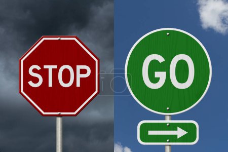 Téléchargez les photos : Go and Stop with an arrow message on green street sign with blue sky - en image libre de droit