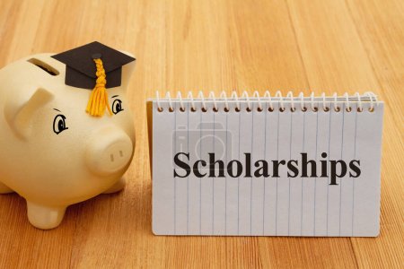 Foto de Scholarships message with gold piggy bank with a grad cap on wood desk for your money or saving for school - Imagen libre de derechos