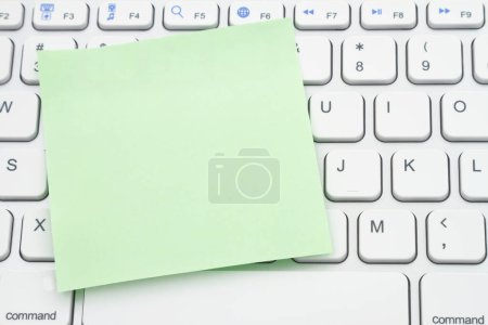 Téléchargez les photos : Blank green sticky note on a profile gray computer keyboard for your online shopping message - en image libre de droit