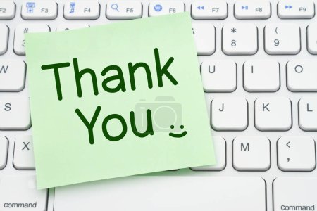 Photo for Thank You message on a green sticky note on a gray computer keyboard - Royalty Free Image