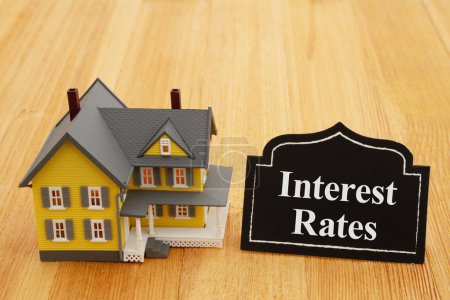 Foto de Interest rates for real estate with chalkboard sign and a house on a wood desk - Imagen libre de derechos