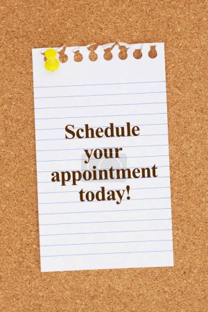 Téléchargez les photos : Schedule your appointment today message on ruled paper with a pushpin on a corkboard - en image libre de droit