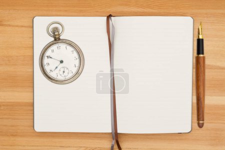 Foto de Diario forrado con viejo reloj de bolsillo de moda y pluma estilográfica en escritorio de madera para su mensaje de escritura diario - Imagen libre de derechos