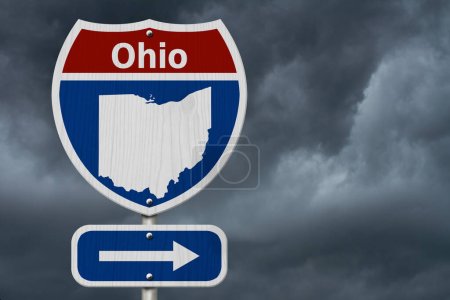 Viaje por carretera a Ohio, señal de tráfico interestatal roja, blanca y azul con palabra Ohio y mapa de Ohio con un fondo de cielo tormentoso