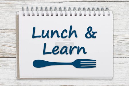 Téléchargez les photos : Lunch and Learn message with a fork on a notepad on weathered wood - en image libre de droit