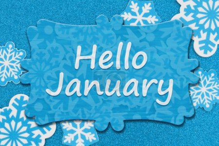 Photo for Hello January message on wood sign on snowflakes on blue glitter material - Royalty Free Image