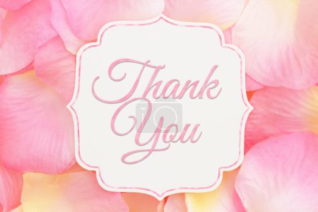 Foto de Mensaje de agradecimiento en una etiqueta de regalo beige con pétalos de rosa rosa y amarillo para su mensaje de San Valentín o aniversario - Imagen libre de derechos