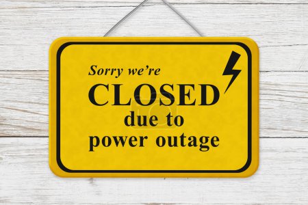 Photo for Closed due to power outage message yellow hanging warning sign on weathered wood - Royalty Free Image