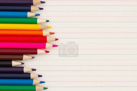 Foto de Lápices de color en fondo de papel de cuaderno de línea reglada vintage para usted educación o mensaje escolar - Imagen libre de derechos
