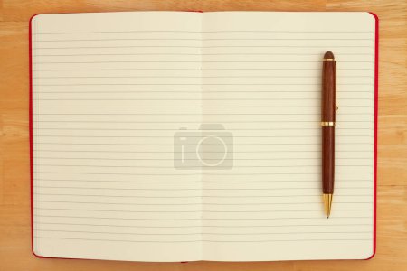 Foto de Diario forrado con un bolígrafo en el escritorio de madera para su mensaje diario de escritura - Imagen libre de derechos