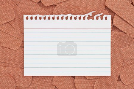 Photo for Blank index card with lots of fabric adhesive band aids with for your medical or injury message - Royalty Free Image