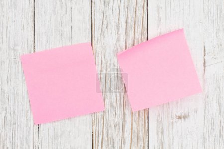 Foto de Dos notas adhesivas de color rosa en blanco sobre madera envejecida para su negocio o aviso de trabajo - Imagen libre de derechos