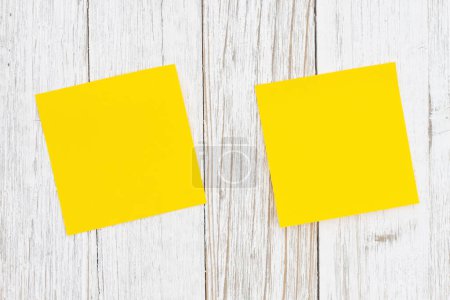 Téléchargez les photos : Deux blanc jaune collant note sur bois altéré pour votre entreprise ou avis de poste - en image libre de droit