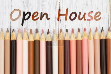 Photo for Open house message with multiculture skin tone color pencils on weathered wood desk - Royalty Free Image