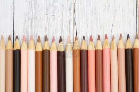 Multicultura lápices de color tono de piel fondo en madera del tiempo para usted educación o mensaje escolar