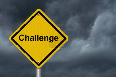Téléchargez les photos : Avertissement Challenge Ahead Sign, Un panneau d'avertissement routier américain avec mot Challenge avec un fond de ciel orageux - en image libre de droit