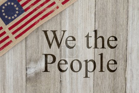 Foto de Mensaje patriótico de Estados Unidos, vieja bandera patriótica de Estados Unidos sobre un fondo de madera envejecida con texto We the People - Imagen libre de derechos