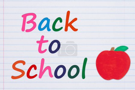 Foto de Volver al mensaje de la escuela con una manzana en papel de cuaderno de línea reglada vintage para usted educación o mensaje de la escuela - Imagen libre de derechos