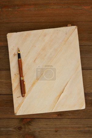Photo for Retro old book with a calligraphy pen background on weathered desk for writing or journaling - Royalty Free Image