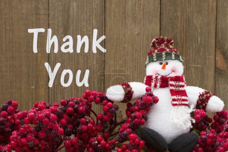 Téléchargez les photos : Merci message, Frost couvert de baies de houx rouge avec un bonhomme de neige sur fond de bois altéré avec texte Merci - en image libre de droit