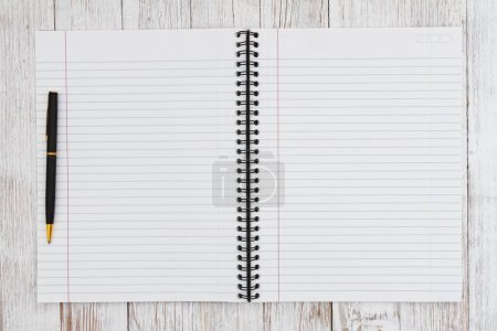 Photo for Ruled line journal paper page notepad with pen background on weathered desk for writing or journaling - Royalty Free Image