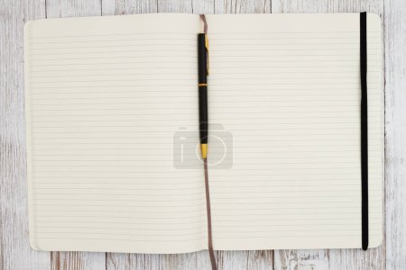 Foto de Cuaderno de notas de la página de papel de la revista de línea reglamentada con fondo de pluma en el escritorio envejecido para escribir o escribir en diario - Imagen libre de derechos