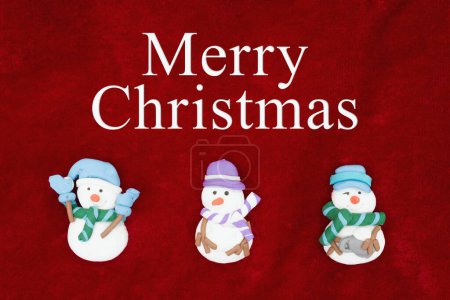 Téléchargez les photos : Joyeux vœux de Noël, tissu peluche rouge avec trois bonhommes de neige fond avec texte Joyeux Noël - en image libre de droit