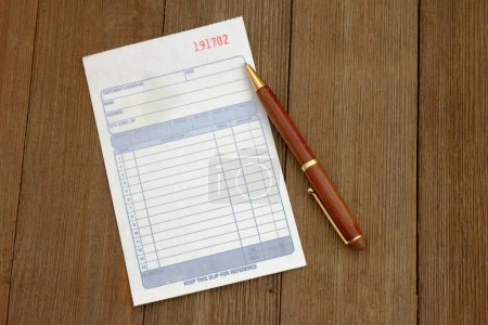 Business customer receipt with pen on a weathered desk