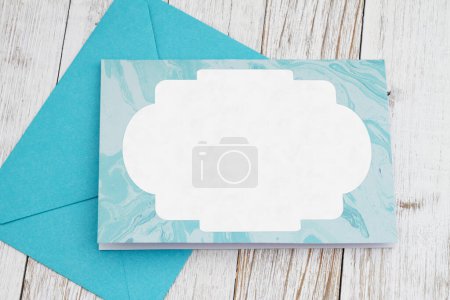 Téléchargez les photos : Carte de vœux vierge avec enveloppe bleue sur bois altéré - en image libre de droit