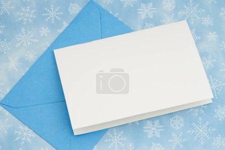Téléchargez les photos : Carte de vœux vierge avec enveloppe bleue sur flocons de neige d'hiver - en image libre de droit