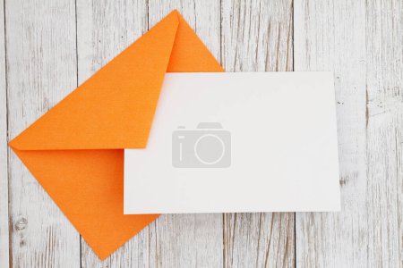 Photo for Blank greeting card with orange envelope on weathered wood - Royalty Free Image