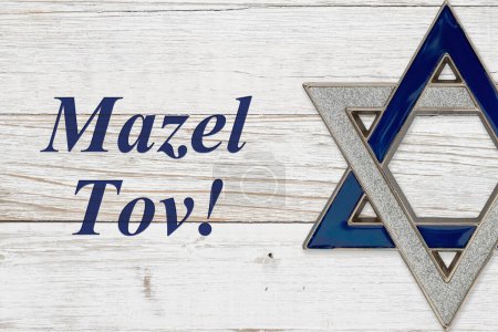 Mazel Tov Botschaft mit silbernem und blauem Davidstern auf verwittertem weißem Holz