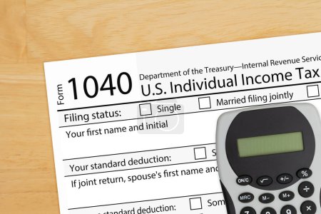 Foto de 1040 formulario de impuesto nosotros impuesto sobre la renta individual con calculadora en un escritorio de madera - Imagen libre de derechos