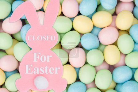 Photo for Closed for Eater sign with a pink bunny and pale Easter eggs candy - Royalty Free Image
