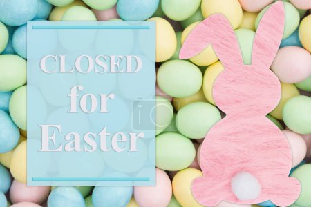 Photo for Closed for Eater sign with a pink bunny and pale Easter eggs candy - Royalty Free Image