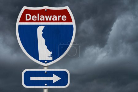 Téléchargez les photos : Road trip au Delaware, Panneau routier inter-états rouge, blanc et bleu avec mot Delaware et carte du Delaware avec fond de ciel orageux - en image libre de droit