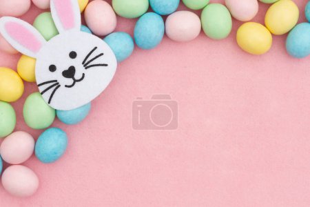 Foto de Huevo de Pascua pálido con fondo de conejo sobre fieltro rosa - Imagen libre de derechos