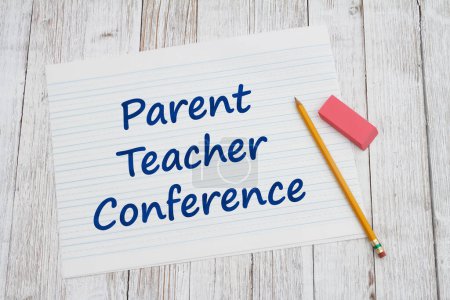 Téléchargez les photos : Conférence des parents enseignants sur papier ligné avec crayon pour l'école sur bureau en bois altéré - en image libre de droit