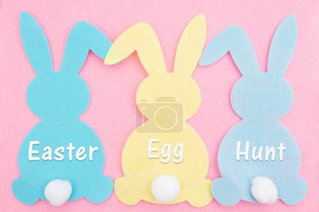 Easter Egg Hunt sign with a bunny pink, blue and yellow on weathered wood