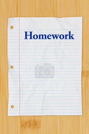  Homework message on crumpled lined rule paper on wood desk