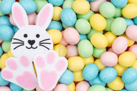 Photo for Pale Easter egg candy with bunny rabbit background - Royalty Free Image